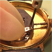 Battery retained by screw clip